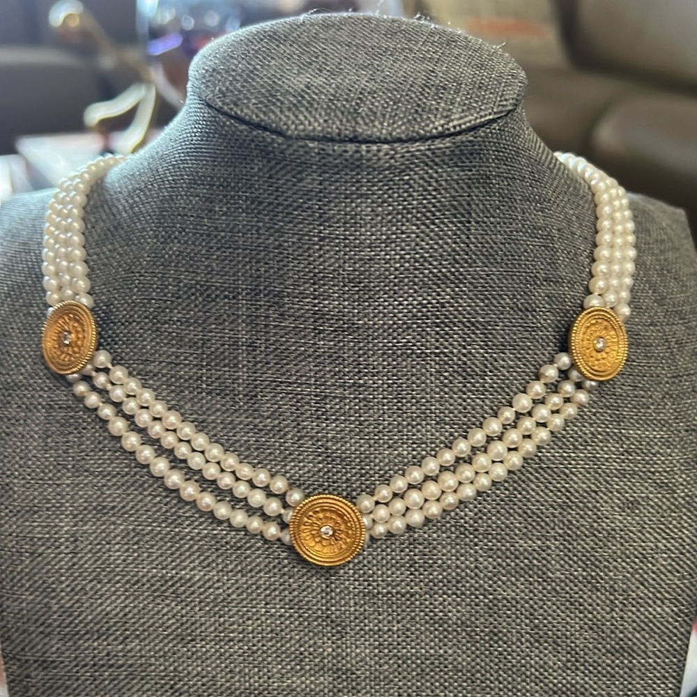 Pearl necklace with 18 karat gold, round charms, and diamond in the middle